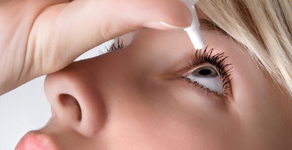 Woman applying eye drops