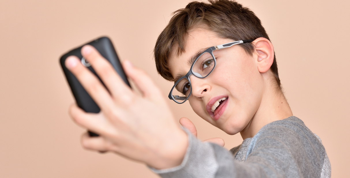 Child in glasses with cell phone