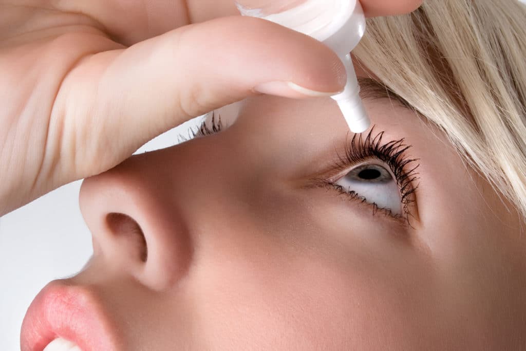 Woman putting in eye drops